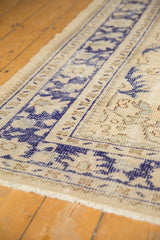 Distressed vintage Oushak rug with ivory pile, cobalt blue border, intact selvage.