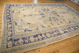 Corner of vintage distressed Oushak rug, with faded cobalt blue border and worn pile texture.