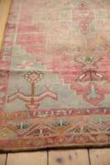 Distressed Oushak runner detail: faded red, blue geometric motifs with visible foundation.