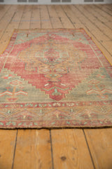 Distressed Oushak rug runner's worn pile, with faded cochineal red, deep gold, and slate blue.