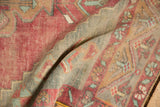 Distressed pile texture of the vintage Oushak runner, with faded cochineal red and exposed foundation.
