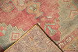 Vintage distressed Oushak runner corner revealing faded red pile, woven reverse, and yellow selvage.