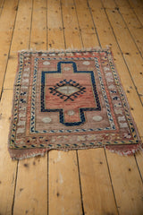 Distressed corner of a vintage Anatolian rug with worn fringe and muted rose tones.