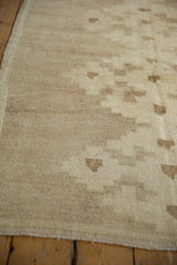 Distressed texture of ivory and beige Oushak rug with subtle geometric pattern.