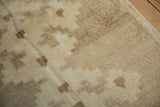 Distressed vintage Oushak rug pile with abrashed beige tones and stepped geometric pattern.