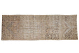 Decorative distressed Oushak rug runner, featuring faded sand and ivory floral medallions, 3'3