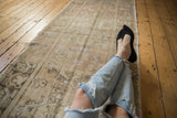 Distressed vintage Oushak runner texture, with muted sand, ivory, and slate blue tones.