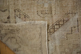 Reverse of vintage distressed Oushak rug, showcasing hand knotted foundation and selvage.