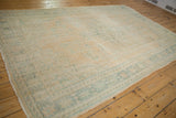 Detail of distressed vintage Oushak rug, showing faded apricot field and ocean green vinery.
