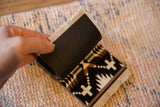 Dark textured backing, light fringe, and geometric pattern on a Spider Rock coaster.