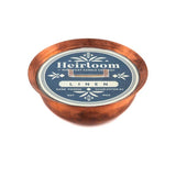 Polished copper kettle soy candle with an oval blue Heirloom Linen label.