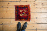 Hand-knotted Oushak square mat with bursting serrated floral design and vibrant gem-tone colors.