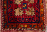 Vintage Oushak rug corner detail with cherry red field, beige serrated florals, tangerine orange border.