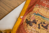 A small hole showing age and wear on the yellow felt border of the vintage pennant.