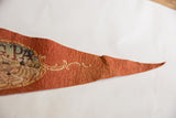 The pointed tip of the vintage Gettysburg pennant showing storied wear and cream scrolls.