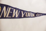 Dark blue vintage felt pennant detail, displaying 'NEW YORK CITY' in off-white text.