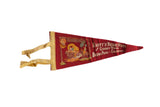 A vintage Knott's Berry Farm felt flag in red with colorful Ghost Town graphics and yellow ties.
