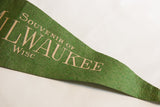 Green felt texture with light beige 'SOUVENIR OF MILWAUKEE WISC' text.