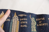 Close-up of dark blue felt flag showing Empire State Building, dirigible, and Statue of Liberty.