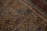 Antique Belouch rug: geometric guls, pawn motif, camel, madder, aubergine, and visible repairs.