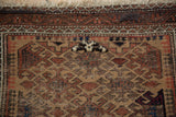 Antique Belouch rug's geometric pawn motif, rich madder and beige tones, plus overt repair.