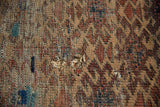 Hard wear, tatter, and holes on antique Belouch rug, showing camel, aubergine weave.