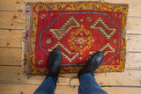 Geometric serrated leaves and central floral medallion on worn vintage Oushak rug.