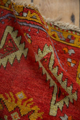 Hand-knotted red vintage Oushak rug detail, with saffron yellow serrated leaf motifs.