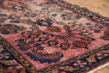 Pale raspberry red Lilihan field with visible wear and cobalt blue floral motifs.