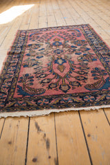 Frayed white foundation and dark blue patterned border of the vintage Lilihan rug.