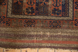 Antique Belouch rug's striped kilim end showing authentic wear and natural fringed edge.