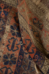 Unusual germinating plant motifs with serpent borders on folded antique Belouch rug.