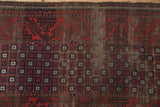 Antique Belouch rug detail: repeating pomegranate starburst motifs in madder red and navy, showing foundation wear.