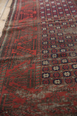Antique Belouch runner's paneled pomegranate starburst motif with deep madder red and visible foundation.
