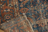 Antique Malayer rug, worn Herati pattern, showing hand-knotted foundation and tattered ends.