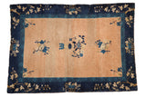 Antique Chinese Peking rug with abrashed peach field, indigo blue floral motifs, and a sprawling vine border. Measures 4'1