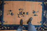 Antique Peking rug with abrashed peach field, indigo blue floral bouquets, and ornate cobalt border.