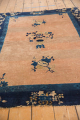 Antique Peking rug's abrashed peach field: low pile, visible knot heads, and foundation.