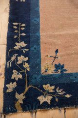 Antique Chinese Peking rug corner, ornate cobalt blue border with sprawling vines, bird, and beige field.