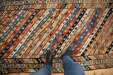 View from above an antique Kurdish runner's textured pile and diagonal ribboned design.