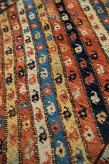 Detailed inline botehs within the colorful, ribboned borders of a hand-knotted antique Kurdish rug.
