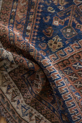 Hand-knotted pile with indigo blue and chestnut brown geometric patterns on antique Afshar rug.
