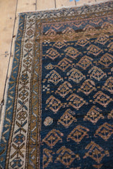 Antique Kurdish rug border shows ivory geometric motifs and deep blue abrashed field.