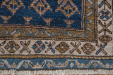 Antique Kurdish rug corner, showing geometric boteh field, layered geometric borders, abrashed blues, bronze, ivory.