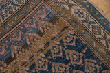 Kurdish rug detail: geometric boteh pattern, abrashed indigo, bronze, pink, and visible wear.