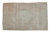 Distressed vintage Turkish Oushak rug with worn roundel medallion, geometric borders in ivory, blush, mint green.