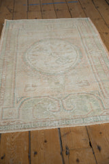 Distressed vintage Oushak pile with geometric T border in pale blush and mint.
