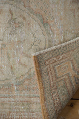Distressed Oushak rug pile texture showing faded ivory and blush, plus woven reverse.