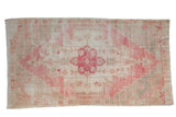 Vintage Distressed Oushak rug with cherry red medallion, faded ivory field, and stepped corner spandrels.