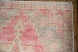 Vintage distressed Oushak rug corner with faded cherry red stepped spandrel and checkered floral.